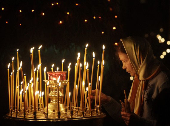 A believer lights candles in a church in Moscow January 6, 2010. Russia celebrates Christmas on January 7, according to the Julian calendar that is used by the country's Orthodox church. REUTERS/Sergei Karpukhin  (RUSSIA - Tags: RELIGION)